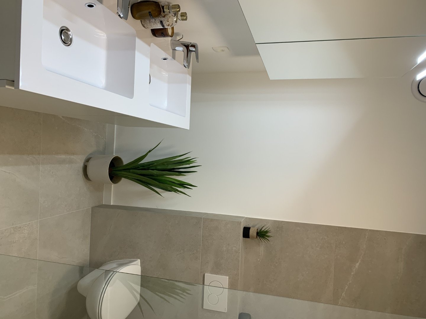 Badkamer met dubbele wastafel en marmerlook tegels