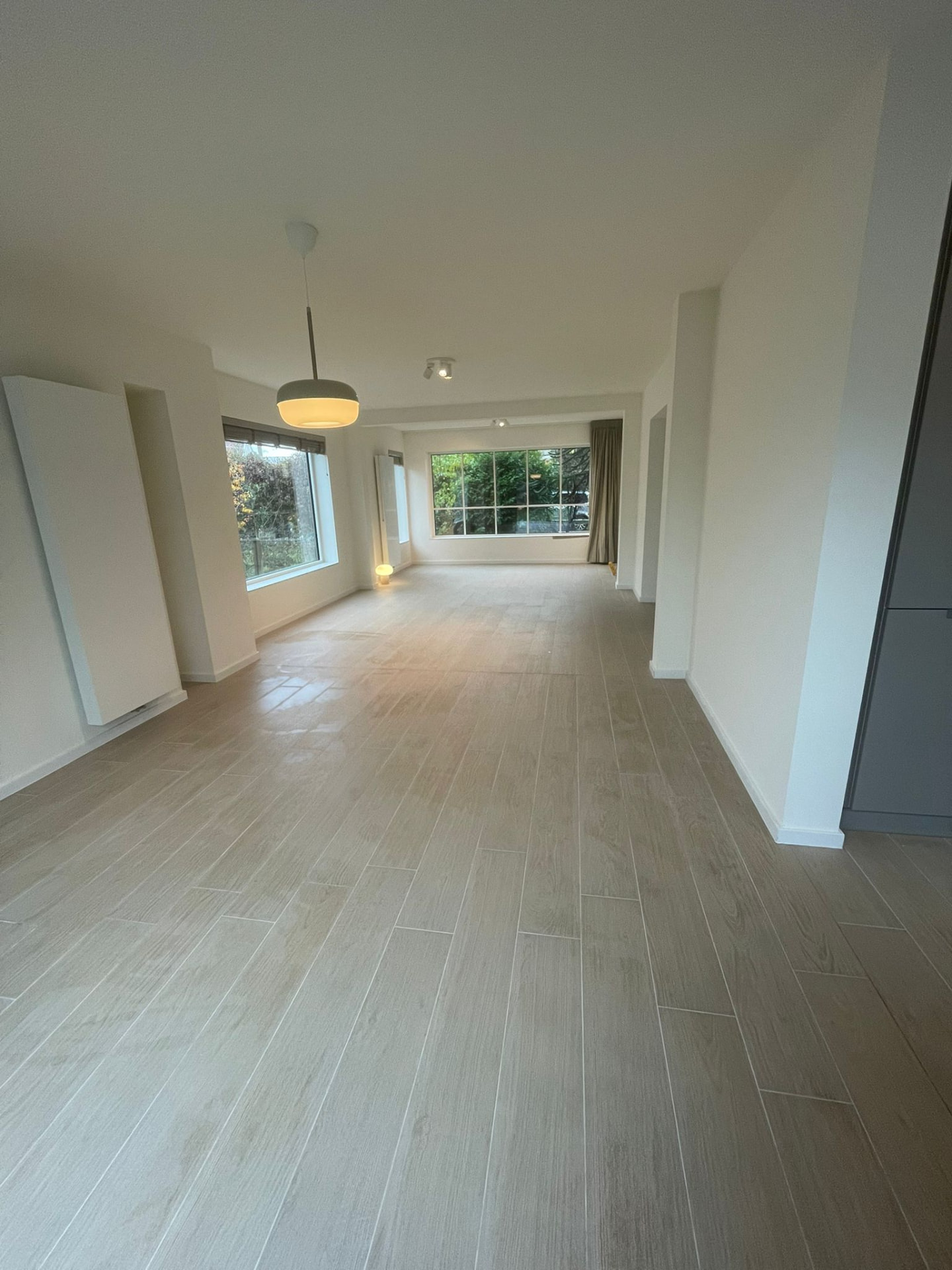 Afgewerkte leefruimte met houtlook tegelvloer