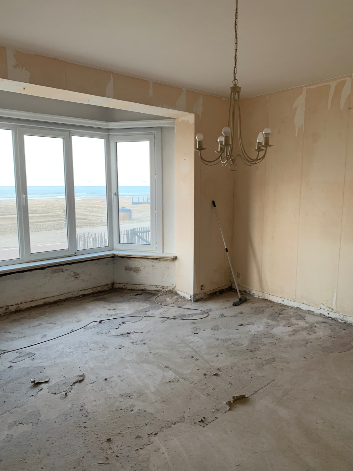 Séjour mis à nu avec bow-window avant la rénovation