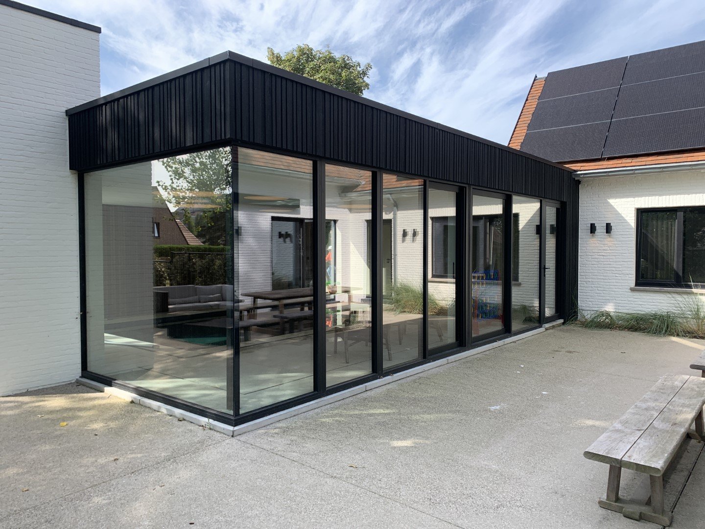 Moderne veranda met zwarte gevelbekleding en glaspartijen